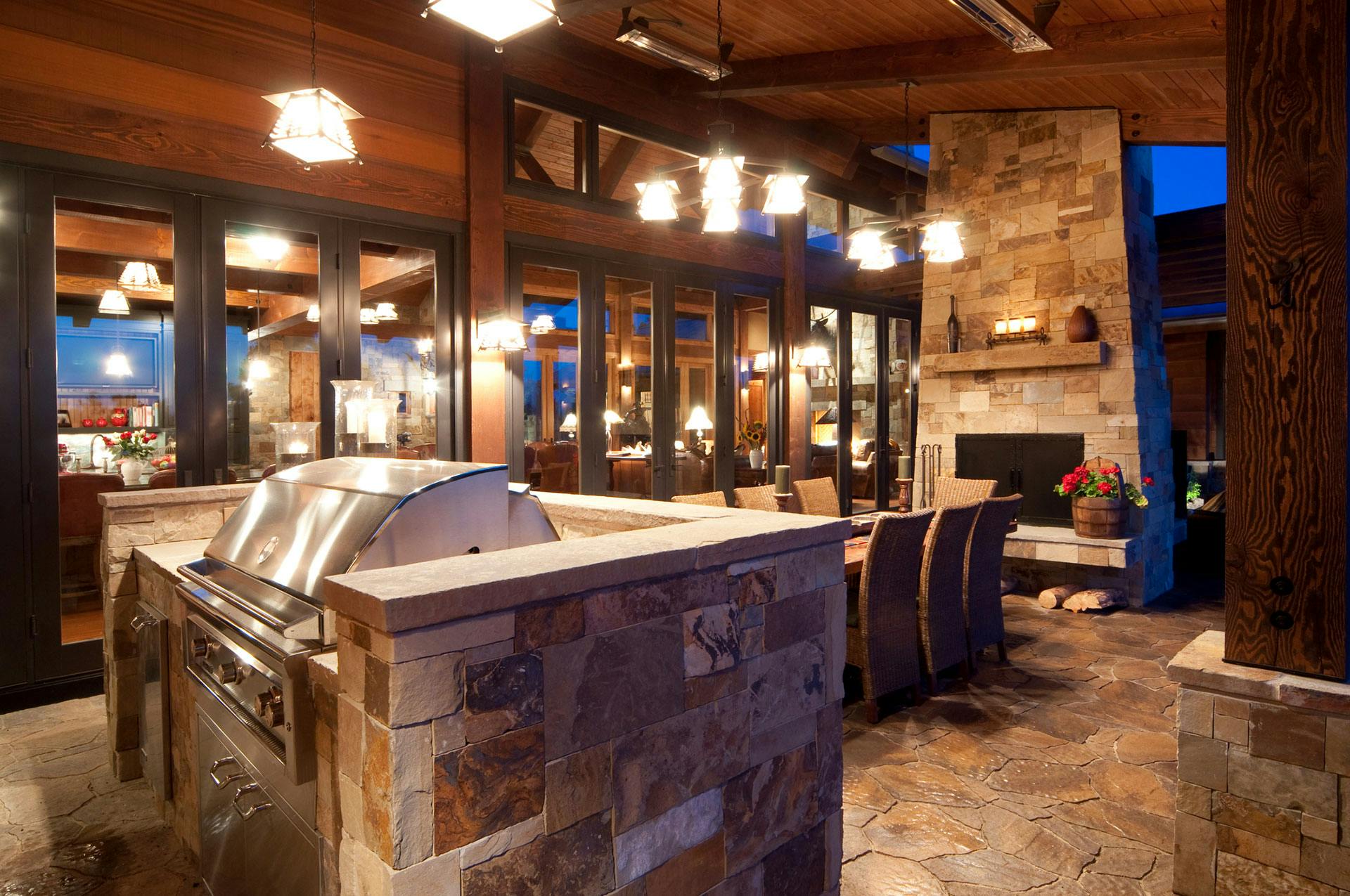 A patio with a grill, lights, and fireplace